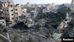 Palestinians gather at the site of an Israeli strike on a house, in Deir Al-Balah