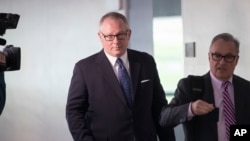 FILE - Former Donald Trump campaign official, later a Department of Health and Human Services spokesperson, Michael Caputo, left, leaves after being interviewed by a Senate committee, on Capitol Hill in Washington, May 1, 2018. 