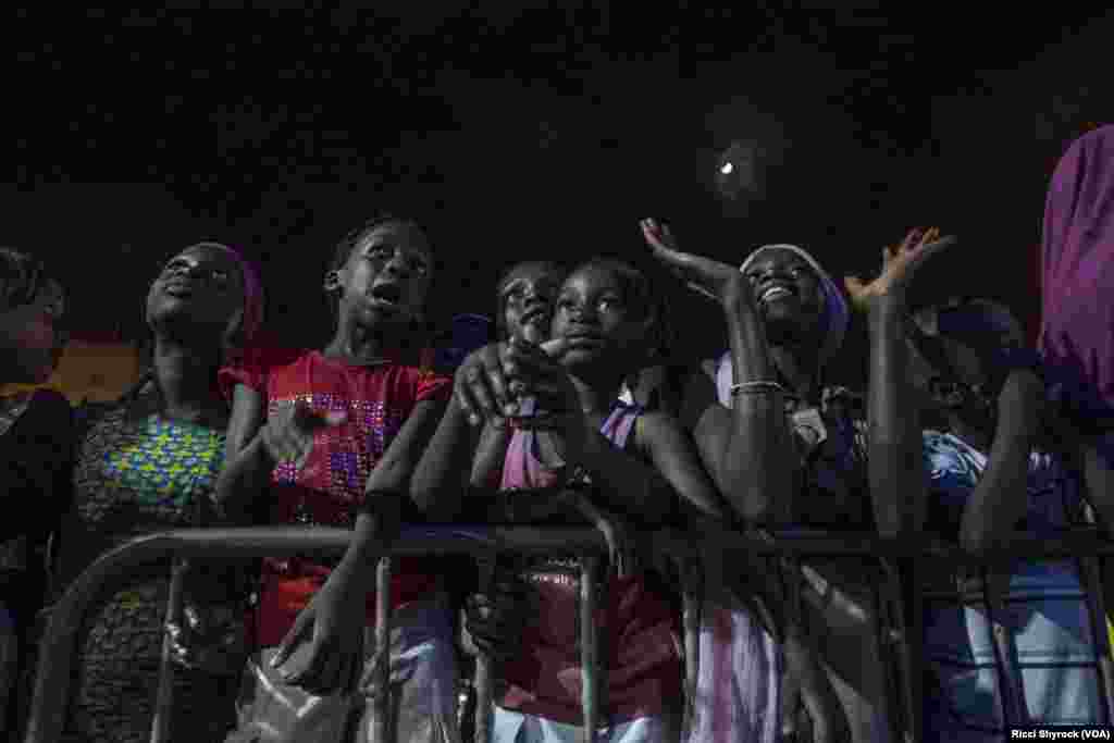 Local youth watch models on the catwalk at Dakar Fashion Week's "Street Parade," in the Niary Tally neighborhood, June 29, 2017.