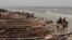 FILE: A horse cart drives through the water past fishing boats lining an oceanside beach, in Saint-Louis, Senegal, Sunday, May 19, 2013.
