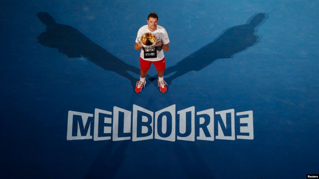 Stanislas Wawrinka dari Swiss berpose dengan piala setelah mengalahkan Rafael Nadal dari Spain di pertandingan final Australia Terbuka 2014 di Melbourne.