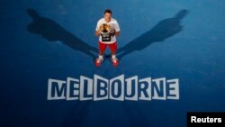 Stanislas Wawrinka dari Swiss berpose dengan piala setelah mengalahkan Rafael Nadal dari Spain di pertandingan final Australia Terbuka 2014 di Melbourne.