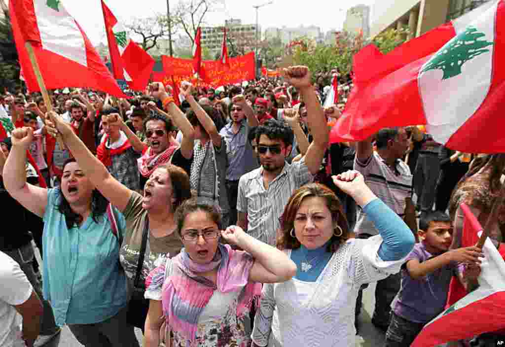 Supporters of the Lebanese Communist party, wave Lebanese flags with the Communist sign printed on them and chant slogans against the Lebanese government, during a demonstration to mark Labor Day, in Beirut, Lebanon, May 1, 2012. (AP Photo)