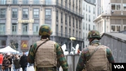 Les forces de sécurité patrouillent devant la Bourse de Bruxelles ou les gens se recueillent publiquement le 23 mars 2016, Bruxelles, Belgique. 