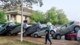 Residents walk near piled up cars following flood in Picanya, near Valencia, eastern Spain, on Oct. 30, 2024.