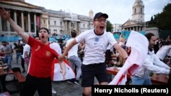 Para fans di Trafalgar Square, London, merayakan gol yang dicetak tim sepak bola Inggris dalam laga Piala Euro atara Ukraine dan Inggris, Sabtu, 3 Juli 2021. (Foto: Henry Nicholls/Reuters)