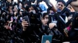 Palestinians standing behind the gate of Rafah crossing in the southern Gaza Strip hold their passports as they try to cross into Egypt. At least 74 Palestinians, most of them civilians, have been killed in Israel&#39;s Gaza offensive, Palestinian officials said.