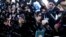 Palestinians standing behind the gate of Rafah crossing in the southern Gaza Strip hold their passports as they try to cross into Egypt. At least 74 Palestinians, most of them civilians, have been killed in Israel's Gaza offensive, Palestinian officials said.