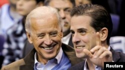 FILE - Then-U.S. Vice President Joe Biden and his son Hunter Biden attend an NCAA basketball game between Georgetown University and Duke University in Washington, Jan. 30, 2010. 