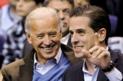 FILE - Then-U.S. Vice President Joe Biden and his son Hunter Biden attend an NCAA basketball game between Georgetown University and Duke University in Washington, Jan. 30, 2010.