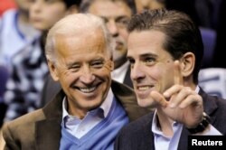 FILE - Then-U.S. Vice President Joe Biden and his son Hunter Biden attend an NCAA basketball game in Washington, Jan. 30, 2010.