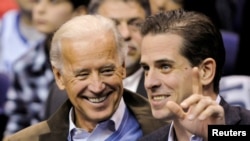 FILE - Then-U.S. Vice President Joe Biden and his son Hunter Biden attend an NCAA basketball game between Georgetown University and Duke University in Washington, Jan. 30, 2010. 