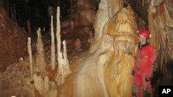 In this 2013 photo provided by Bogdan Onac, researcher Vasile Ersek stands in the Ascunsa Cave in Romania. Scientists say ancient shifts in climate helped our species replace Neanderthals in Europe. Researchers used data from this cave and another to document two lengthy cold and dry periods. (Bogdan Onac via AP)