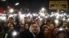 People hold up their cellphones as they rally during a protest against the mandate for Austria's far-right Freedom Party to lead a new government, in Vienna, Austria, Jan. 9, 2025.