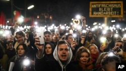 People hold up their cellphones as they rally during a protest against the mandate for Austria's far-right Freedom Party to lead a new government, in Vienna, Austria, Jan. 9, 2025.