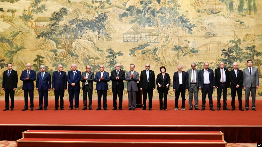 资料照片: 2024年7月23日中国外交部长王毅在北京钓鱼台国宾馆签署《北京宣言》期间与巴勒斯坦派别法塔赫和哈马斯成员合影