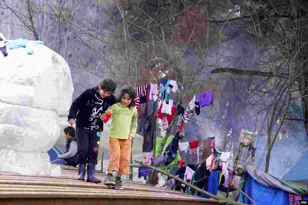 Dua anak pengungsi di kamp Idomeni. (VOA/Jamie Dettmer)