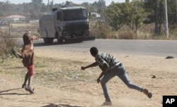 Rioters battle with Zimbabwean police in Harare, Monday, July, 4, 2016.