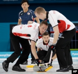 Denmark's skip Rasmus Stjerne, center, makes a call during a men's curling match against Japan at the 2018 Winter Olympics in Gangneung, South Korea, Feb. 20, 2018.
