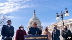 FILE - Sen. Chuck Schumer D-N.Y., center, accompanied by, from left, Reps. Mondaire Jones, D-N.Y., Alma Adams, D-N.C., and Ilhan Omar, D-Minn., Sen. Elizabeth Warren, D-Mass., and Rep. Ayanna Pressley, speaks about student debt relief, Feb. 4, 2021.