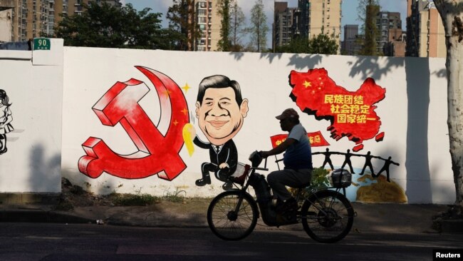 2018年9月28日，上海一条街上的宣传画，包括习近平的漫画形象、中共党徽和中国地图，还有文字“民族团结，社会稳定，国家统一”