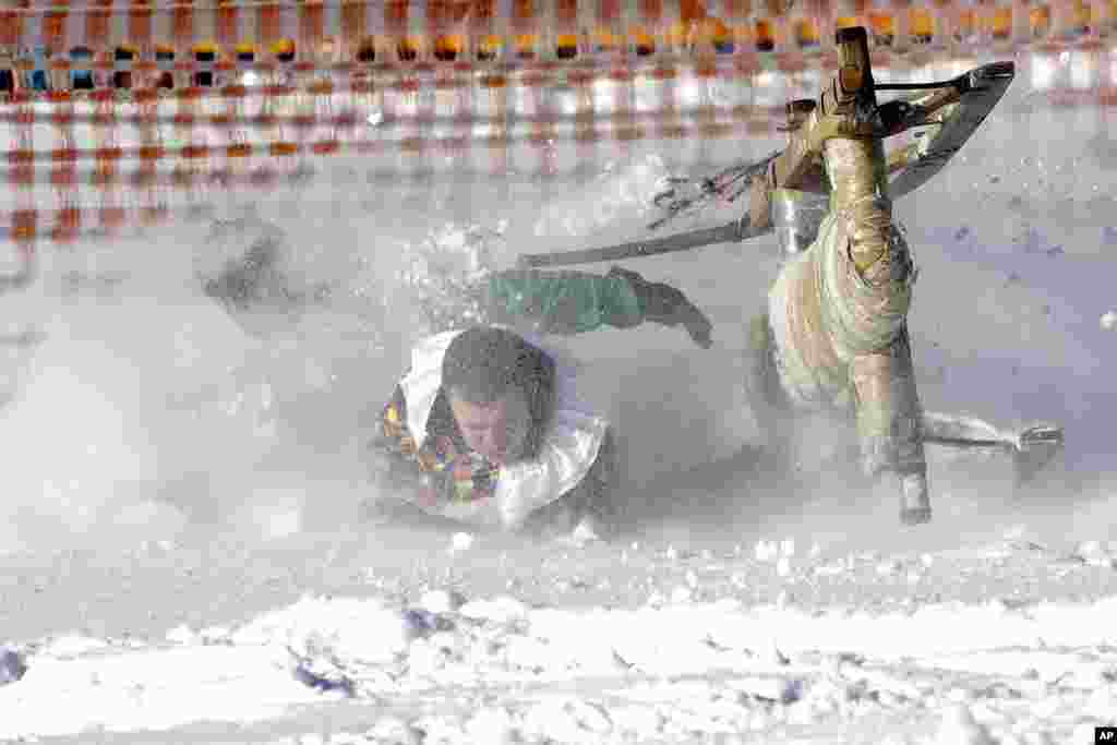 Men crash with their wooden sledge in a fence during a traditional Bavarian horn sledge race, known as &#39;Schnablerrennen&#39; in Gaissach near Bad Toelz, Germany.