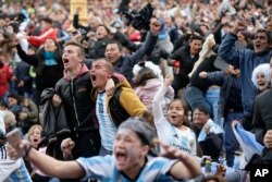 Los fanáticos del fútbol celebran el gol argentino de Marcos Rojo durante una transmisión en vivo del partido de fútbol de la Copa Mundial Rusia 2018 contra Nigeria, en Buenos Aires, Argentina, el martes 26 de junio de 2018. (Foto AP Jorge Saenz)