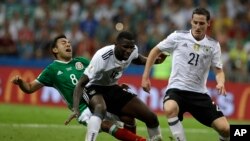 Marco Fabian du Mexique, à gauche, se bat pour récupérer le ballon derrière les Allemands Antonio Ruediger et Sebastian Rudy, à droite, lors du match demi-finale de la Coupe des Confédérations entre l'Allemagne et le Mexique, au Fisht Stadium à Sotchi, Ru