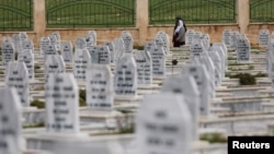 People walk at a cemetery for SDF fighters killed during fightings with Islamic State militants in Kobani, Syria, April 4, 2019.