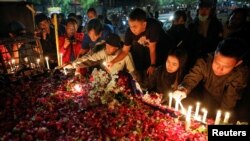Suporter klub sepak bola Arema menyalakan lilin di luar stadion Kanjuruhan untuk menyampaikan belasungkawa kepada para korban pasca kerusuhan di Stadion Kanjuruhan, Malang, Jawa Timur, Minggu 2 Oktober 2022. 