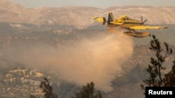 ماموران آتش‌نشانی برای مهار آتش‌سوزی در جنگل جزیره رودس تلاش می‌کنند. ۲۳ ژوئیه ۲۰۲۳.