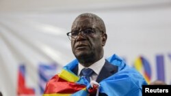 FILE - Democratic Republic of Congo doctor and activist Denis Mukwege, who won the Nobel Peace Prize in 2018, stands wrapped in the national flag after he announced his candidacy for president in Kinshasa on Oct. 2, 2023.