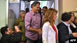 El candidato presidencial de Brasil para el Partido de los Trabajadores (PT), Fernando Haddad (C) llega con su esposa Ana Estela para votar en las elecciones generales, en Sao Paulo, Brasil, el 7 de octubre de 2018. / AFP PHOTO / NELSON ALMEIDA.