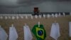 Una bandera brasileña cuelga de un tendedero en la playa de Copacabana en medio de pañuelos blancos que representan a los que han fallecido a causa del COVID-19, en Río de Janeiro, Brasil, el viernes 8 de octubre de 2021. 