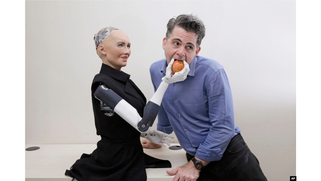 FILE - David Hanson, the founder of Hanson Robotics, poses with his company's flagship robot, Sophia, a lifelike robot powered by artificial intelligence, in Hong Kong, Sept. 28, 2017.