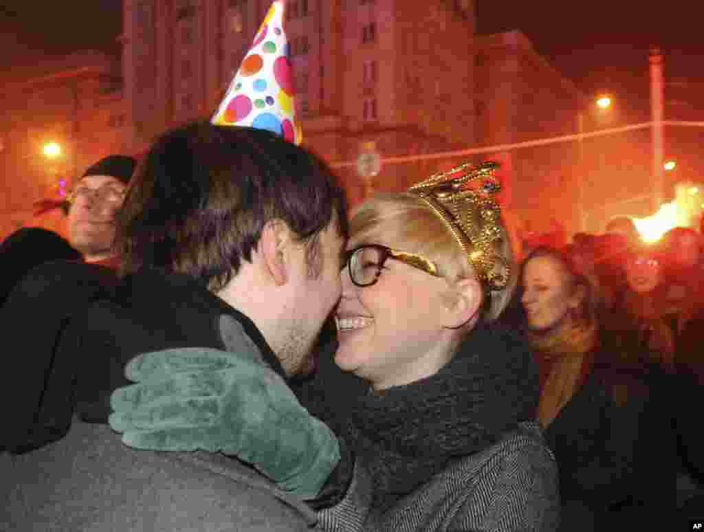 People celebrate as they welcome the New Year at Constitution Square in Warsaw, Poland, Sunday, Jan. 1, 2012. (AP)