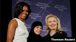 هیلاری کلینتن، وزیر خارجه وقت، و میشل اوباما، بانوی اول وقت آمریکا، به سمر بدوی، فعال حقوق بشر عربستانی، به خاطر کسب جایزه بین‌المللی زنان شجاع ایالات متحده، در سال ٢٠١٢ در واشنگتن تبریک می‌گویند. (منبع: رویترز)