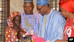 FILE - Nigeria President Muhammadu Buhari, second right, receives Amina Ali, the rescued Chibok school girl, at the Presidential palace in Abuja, Nigeria, May. 19, 2016. 