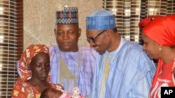 Nigeria President Muhammadu Buhari, second right, receives Amina Ali, the rescued Chibok school girl, at the Presidential palace in Abuja, Nigeria, May. 19, 2016. 