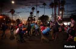 Migrants, part of a caravan of thousands traveling from Central America en route to the United States, make their way to Tijuana from Mexicali, Mexico, Nov. 20, 2018.