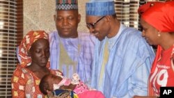 Presiden Nigeria Muhammadu Buhari (kedua dari kanan) menerima Amina Ali, salah seorang gadis Chibok yang berhasil dibebaskan dari penculiknya militan Boko Haram, dalam sebuah acara di Abuja, Nigeria (foto: dok). 