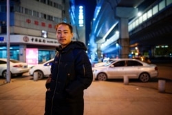An Junming poses for a picture on a street, almost a year after the global outbreak of the coronavirus disease (COVID-19) in Wuhan, Hubei province, China, Dec. 15, 2020.