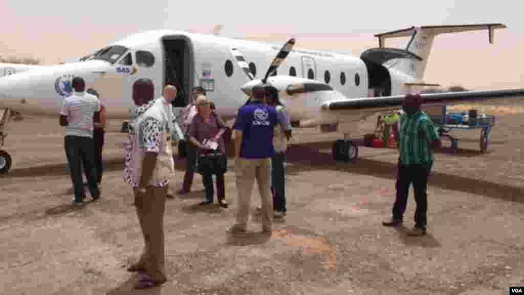 Des journalsites et des travailleurs humanitaires s&#39;apprêtent à s&#39;embarquer dans un avion du Programme mondial pour l&#39;alimnetation à l&#39;aéport de Diffa.