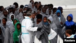 FILE - Migrants disembark from Italian Coast Guard patrol vessel Diciotti in the Sicilian harbor of Catania, Italy, Nov. 16, 2016. Nearly 11,000 asylum-seekers and economic migrants, mainly from African nations, arrived on Italian shores in a four-day period, June 24-27.