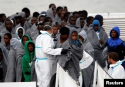 FILE - Migrants disembark from Italian Coast Guard patrol vessel Diciotti in the Sicilian harbour of Catania, Italy, Nov. 16, 2016.