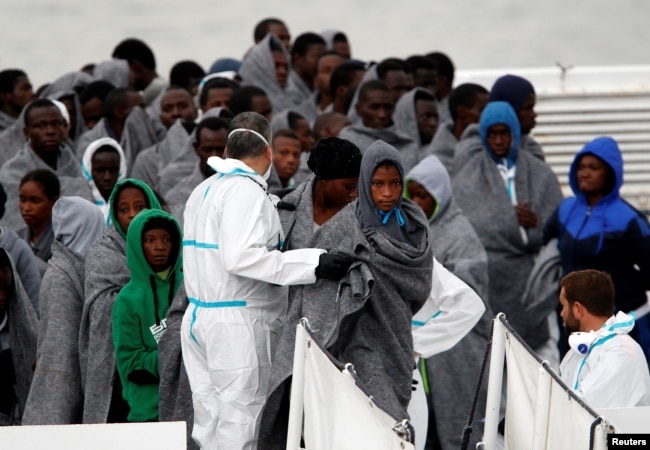 FILE - Migrants disembark from Italian Coast Guard patrol vessel Diciotti in the Sicilian harbour of Catania, Italy, Nov. 16, 2016.