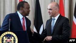 Swiss President Alain Berset (R) speaks with his Kenyan counterpart President Uhuru Kenyatta during a joint press conference at the State House in Nairobi, July 9, 2018, during Berset's official visit. 