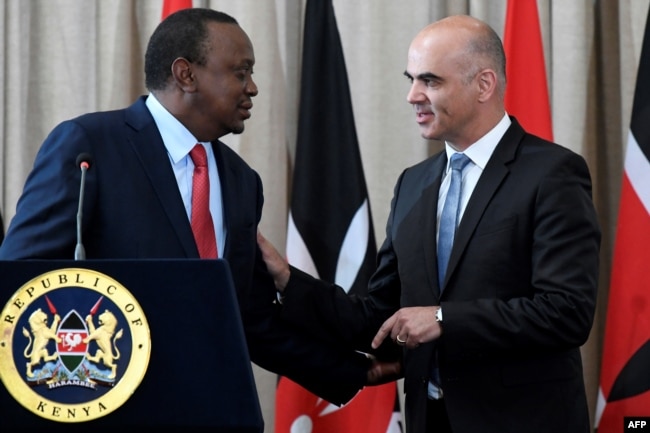 FILE - Swiss President Alain Berset, right, speaks with his Kenyan counterpart President Uhuru Kenyatta during a joint press conference at the State House in Nairobi, July 9, 2018.