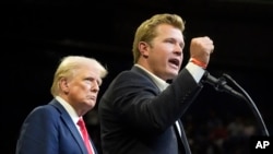 FILE - Republican presidential nominee and former U.S. President Donald Trump listens as Montana Senate candidate Tim Sheehy speaks at a campaign rally in Bozeman, Montana, on Aug. 9, 2024.