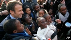 Independent centrist presidential candidate Emmanuel Macron poses with students of the Moliere school for a group photo in Les Mureaux, west of Paris, France, March 7, 2017. 